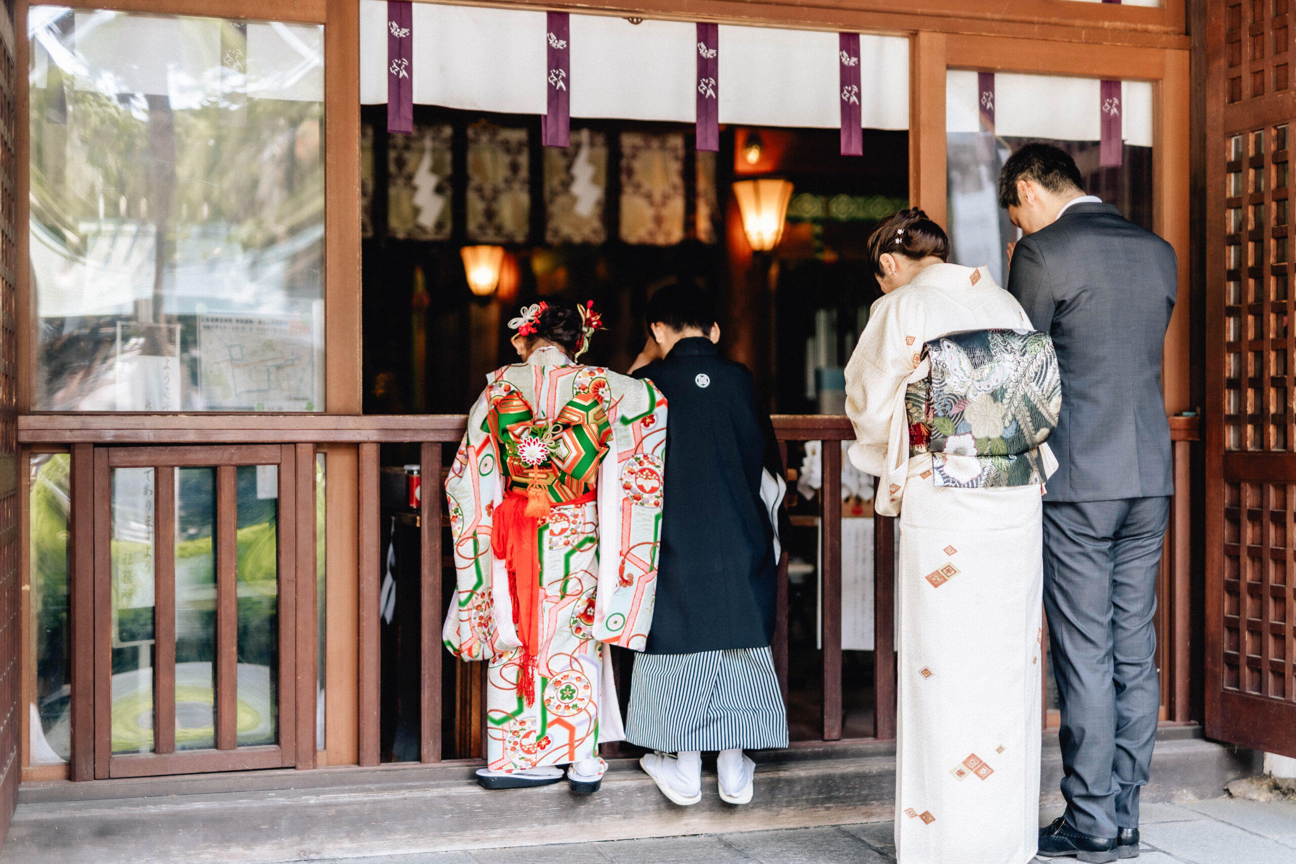 七五三の家族写真｜着物姿の姉弟と両親が神社でお参りする後ろ姿（小樽・余市での出張撮影）