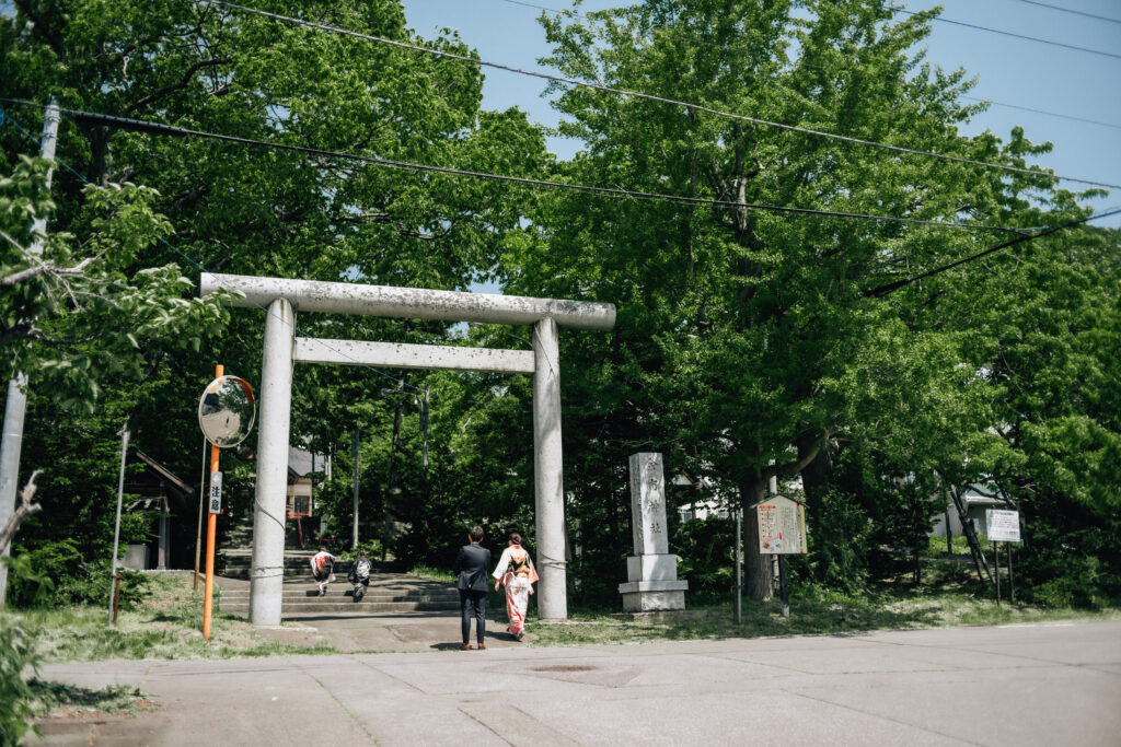余市七五三撮影/七五三を迎える家族が余市神社の鳥居に入っていく様子